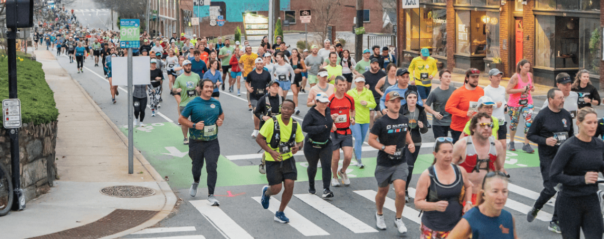 Volunteers needed -- picture of runners in downtown Asheville