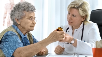 elderly woman getting medication from doctor