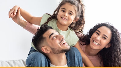 family with little girl on shoulders